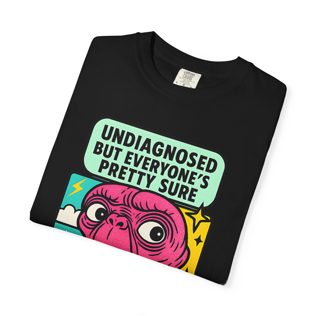 Flat lay of folded black Comfort Colors t-shirt featuring pink alien and "Undiagnosed" text.
