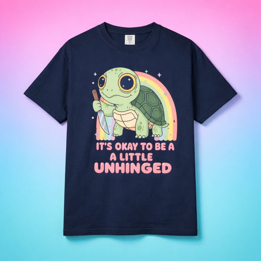 Navy blue graphic tee centered on a pink and blue gradient background.