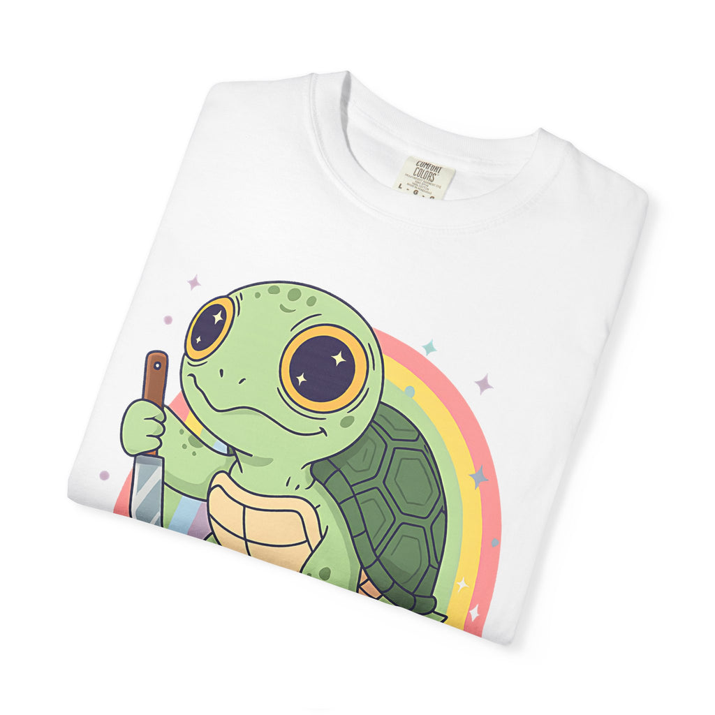 Flat lay of a folded white Comfort Colors t-shirt featuring a cartoon turtle holding a knife with a rainbow background.